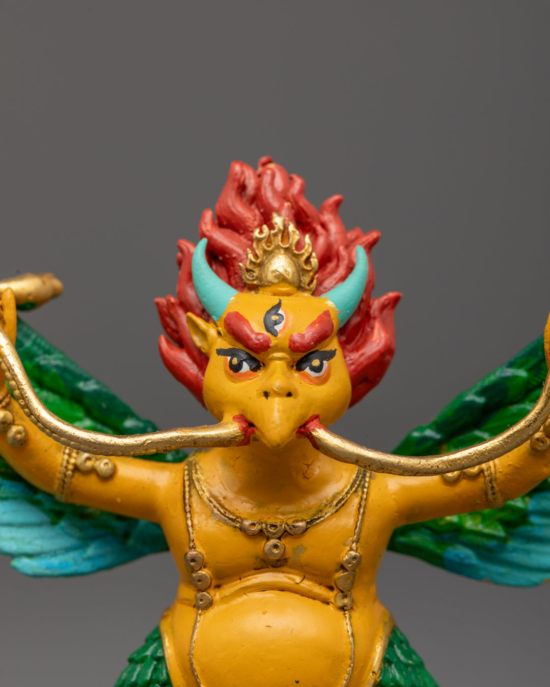 multi-coloured wings and vibrant acrylic colors on Garuda Dev figurine