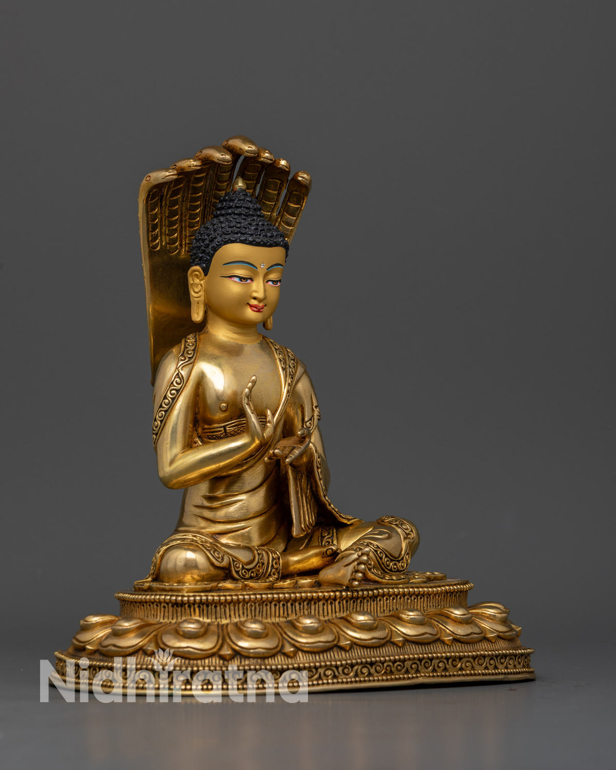 Nagarjuna Buddhist sculpture with a seven cobra Naga halo and intricate gold gilded ornaments.