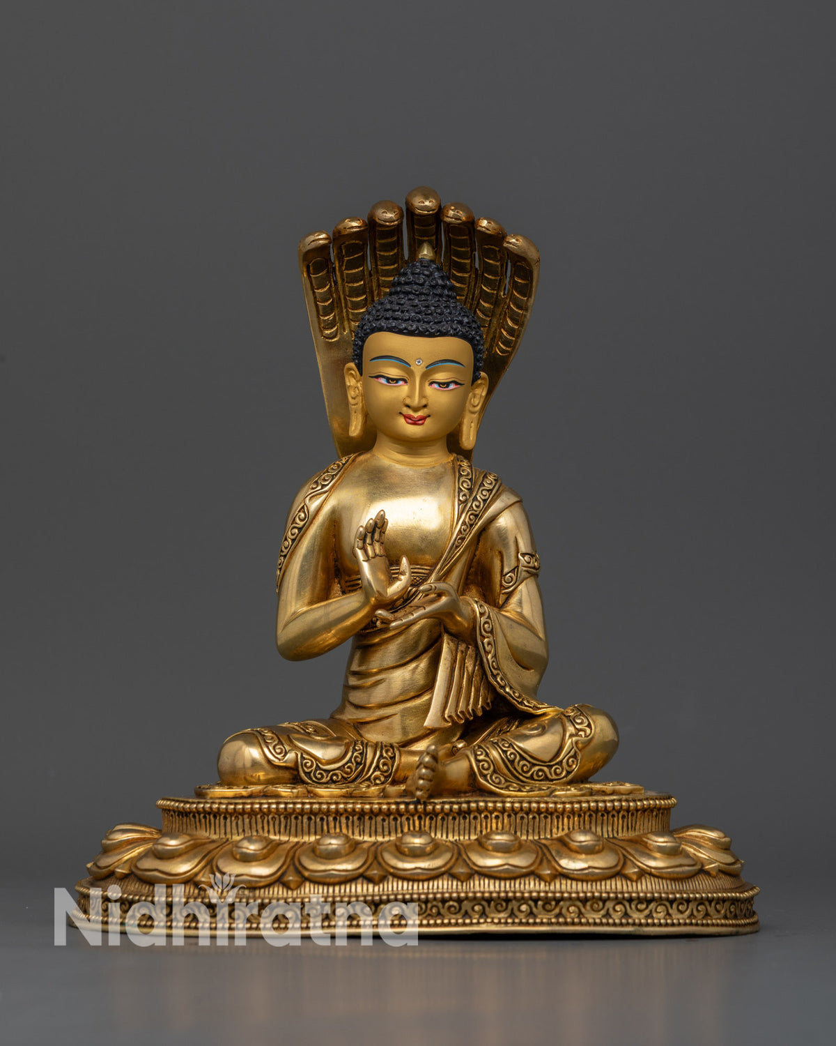 Nagarjuna statue seated on a detailed lotus base with a seven cobra Naga halo.