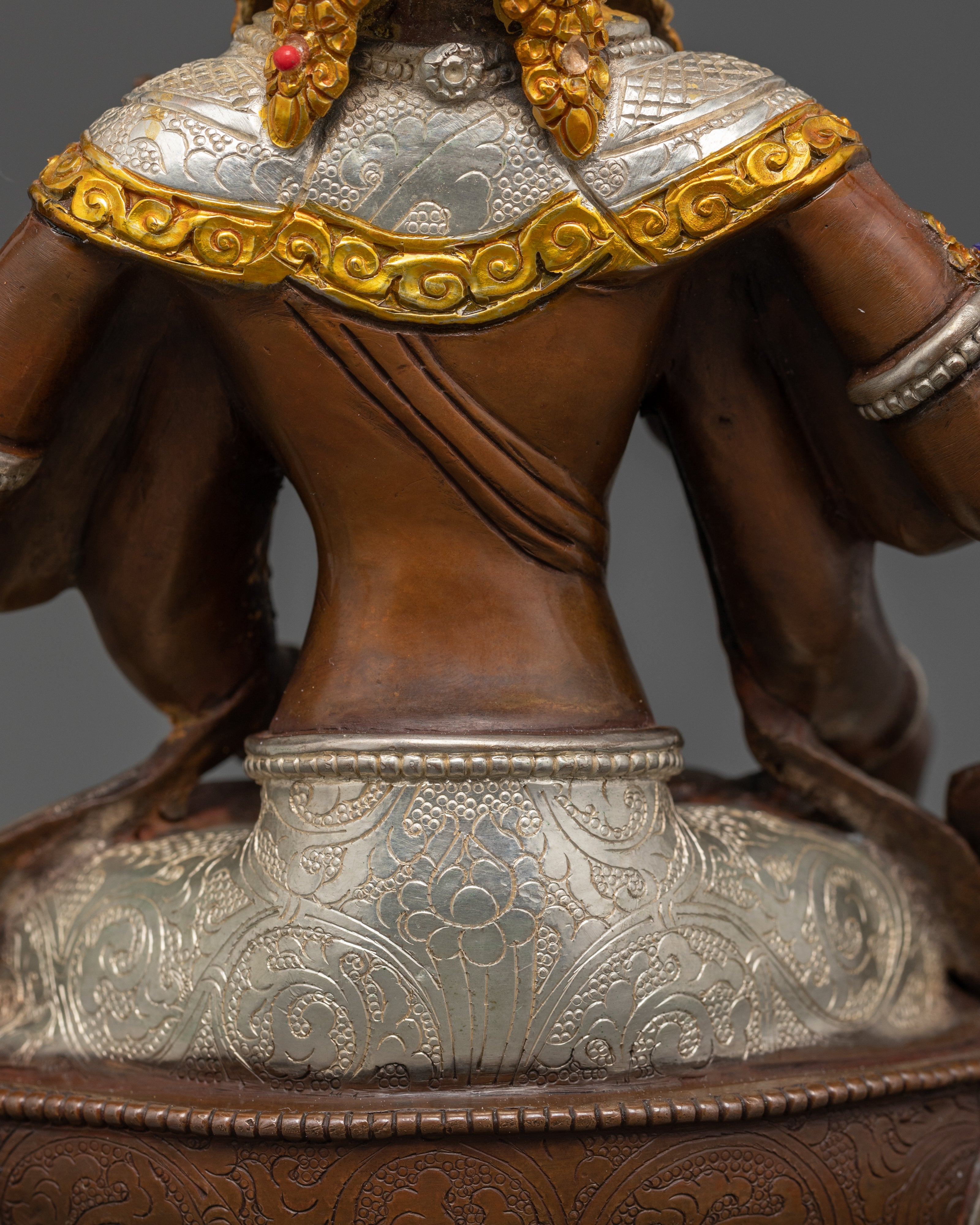 lower back view of golden and brown namgyalma statue