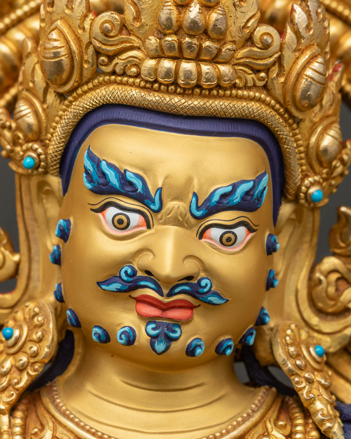 Namtoshe Vaishravana face, detailed close up of fierce expression with blue brows and flame-tipped crown
