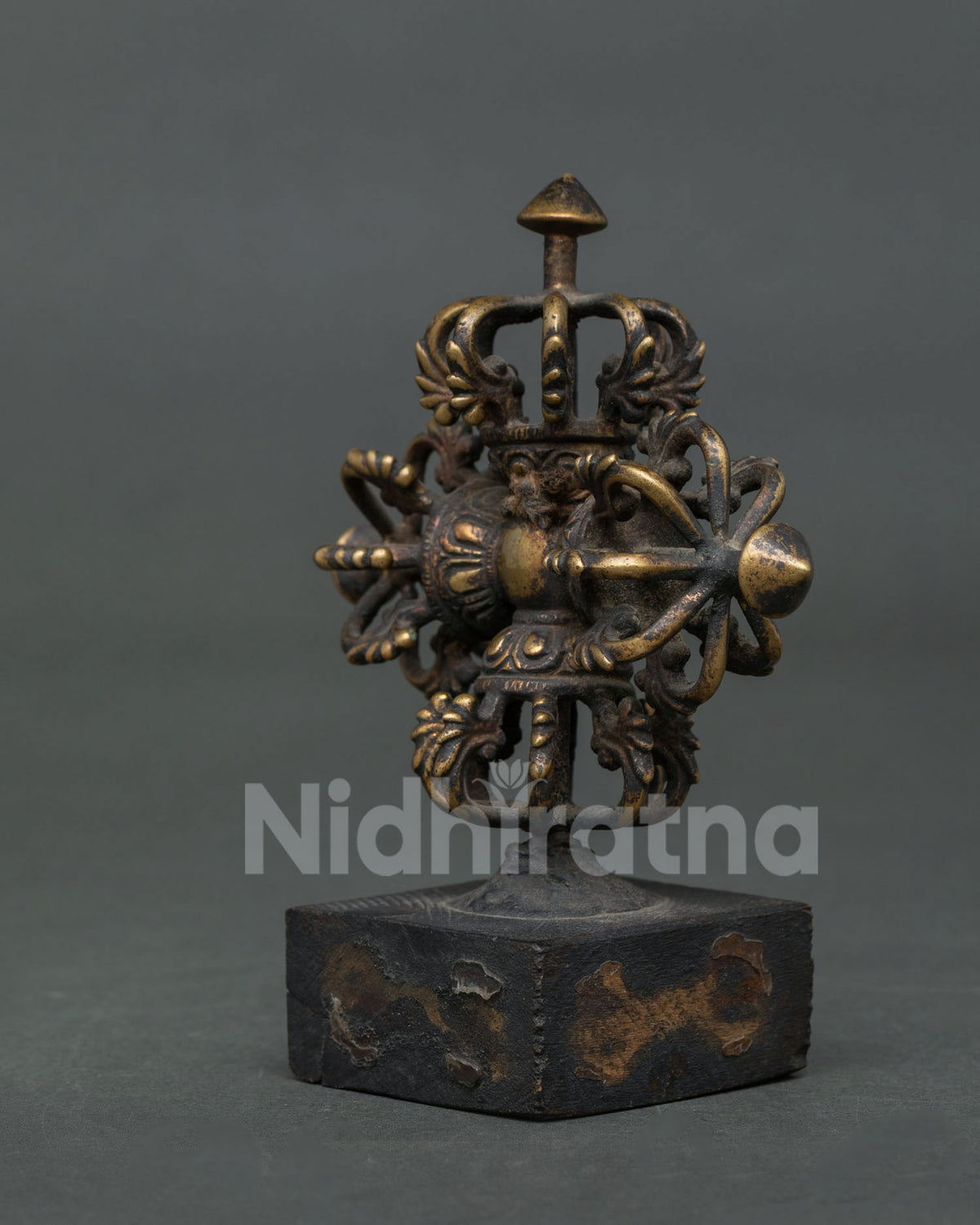Nepalese Bishow Vajra made from copper with chemically oxidized antique finish displayed on a decorative stand.