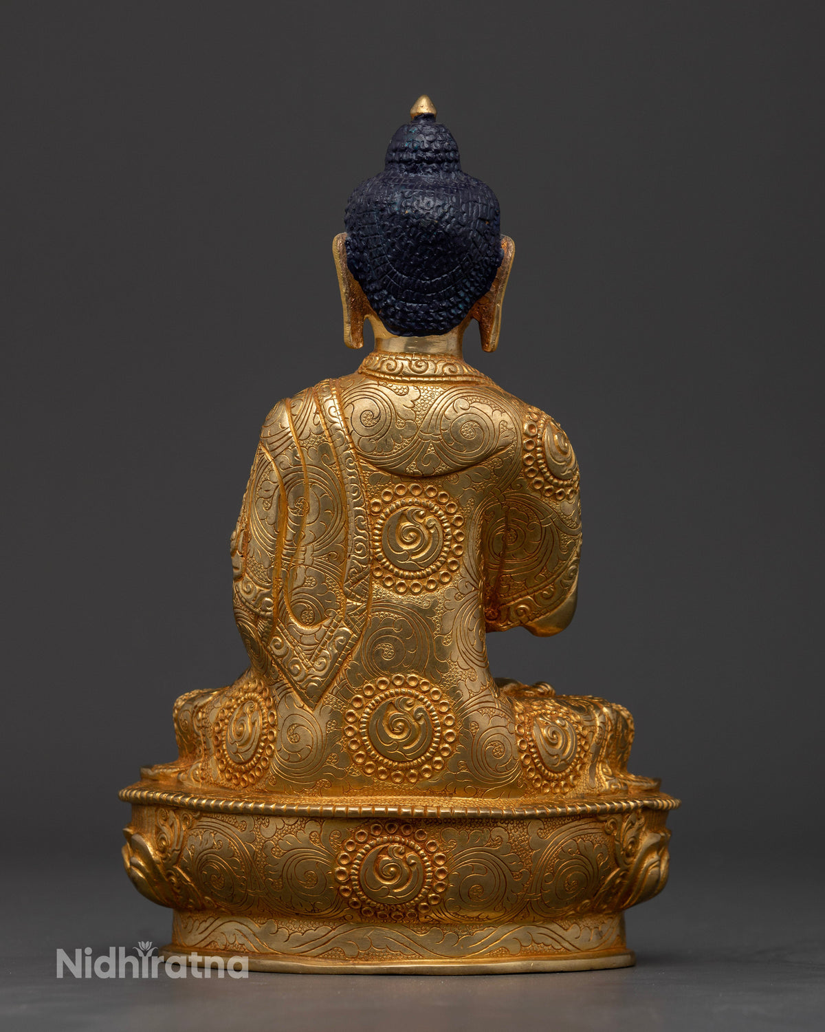 Nepalese copper vairocana buddha statue with floral monk robe motifs.