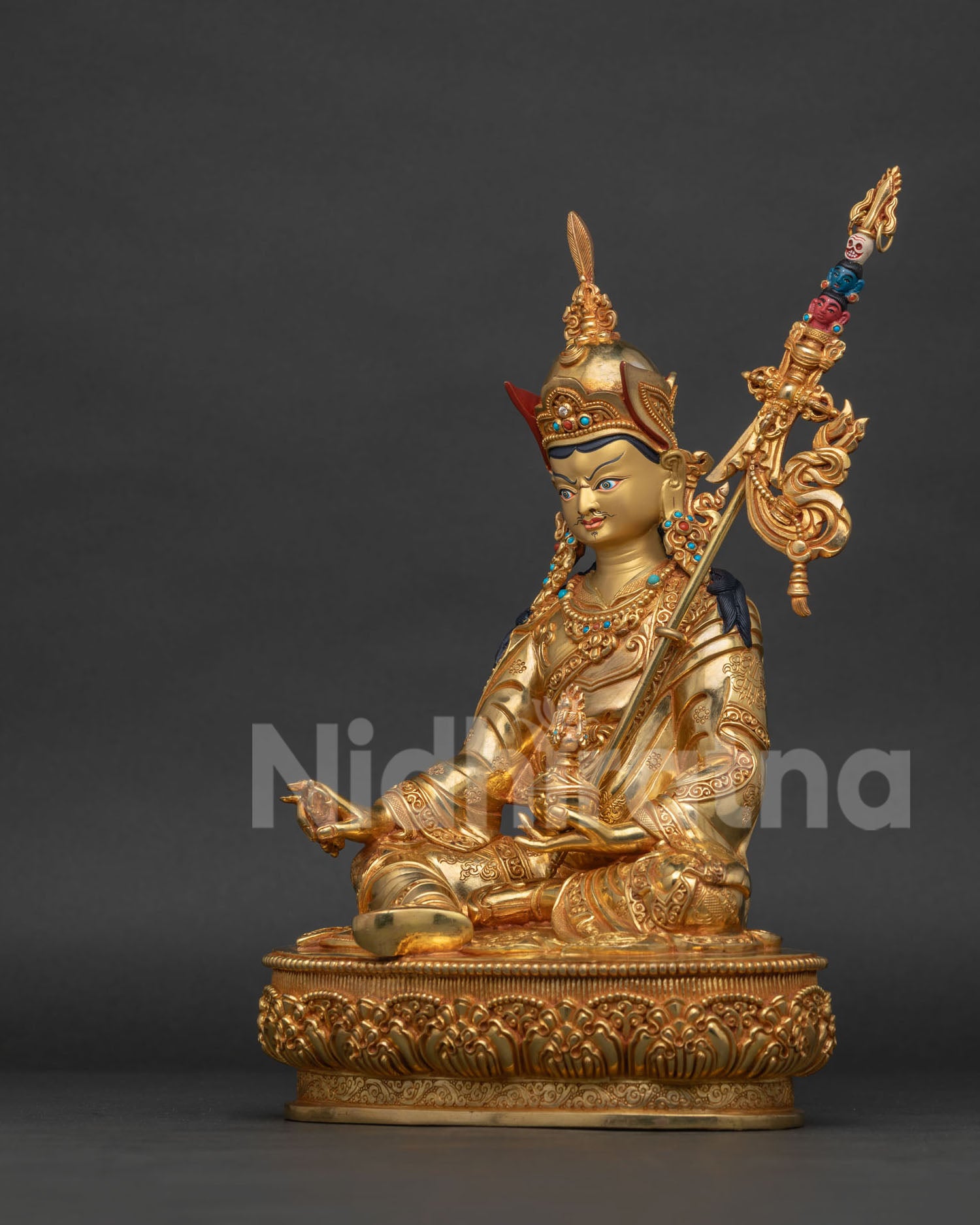 Nepalese Guru Rinpoche statue with intricate royal garment and lotus pedestal.