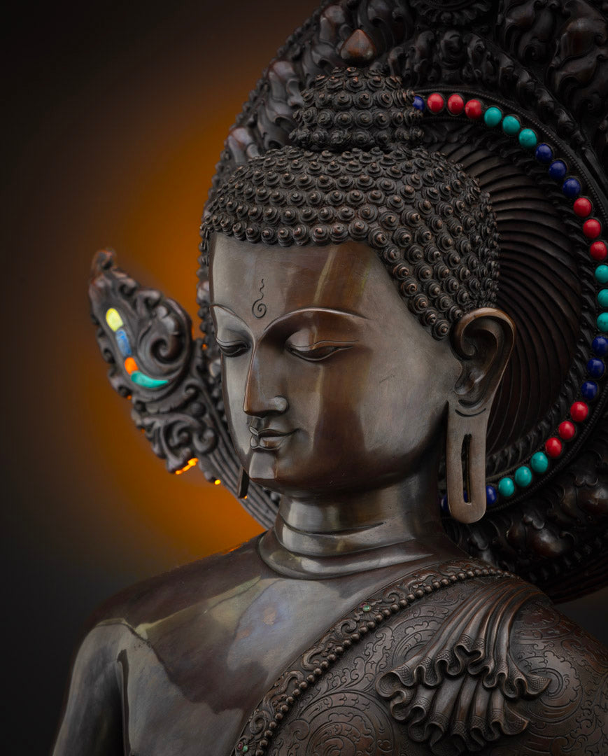 Side close up of oxidized copper Buddha statue showing aureole detail