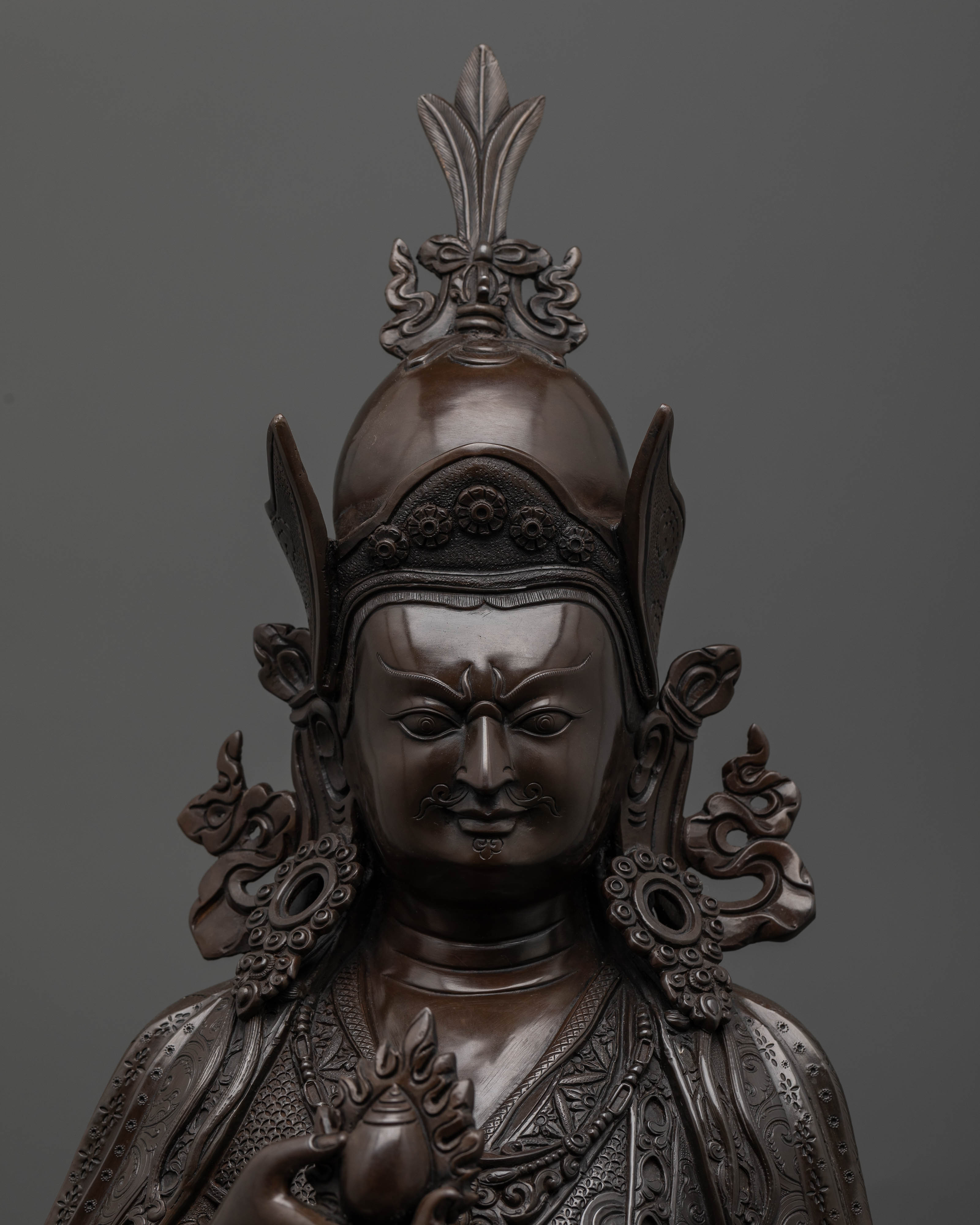 Oxidized copper Guru Norlha statue with intricate three dimensional carvings