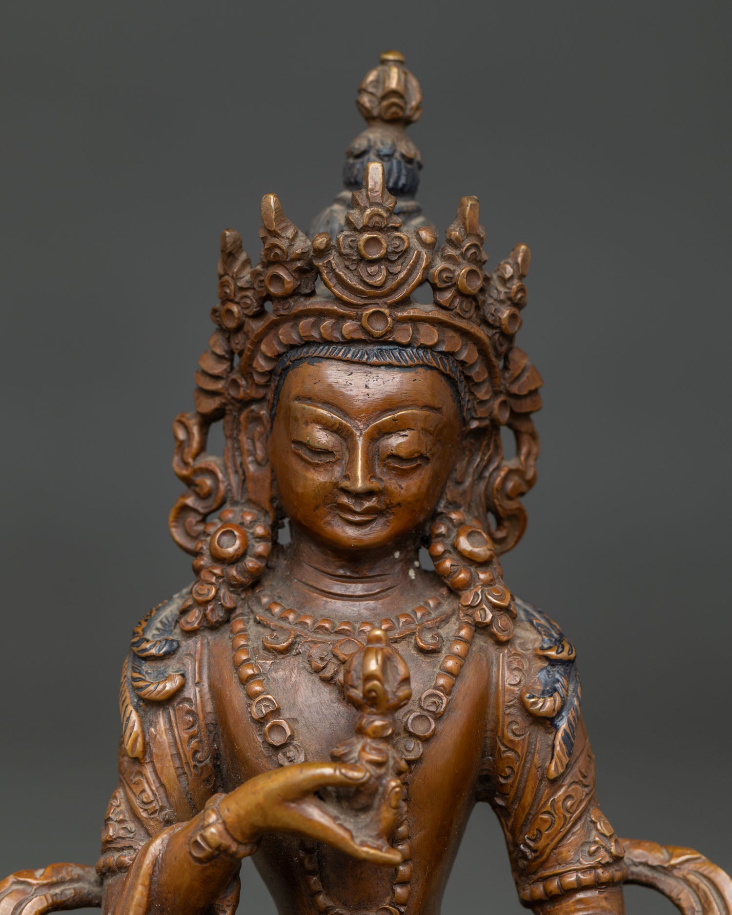 Oxidized Vajrasattva statue with jeweled crown and ornate ornaments.