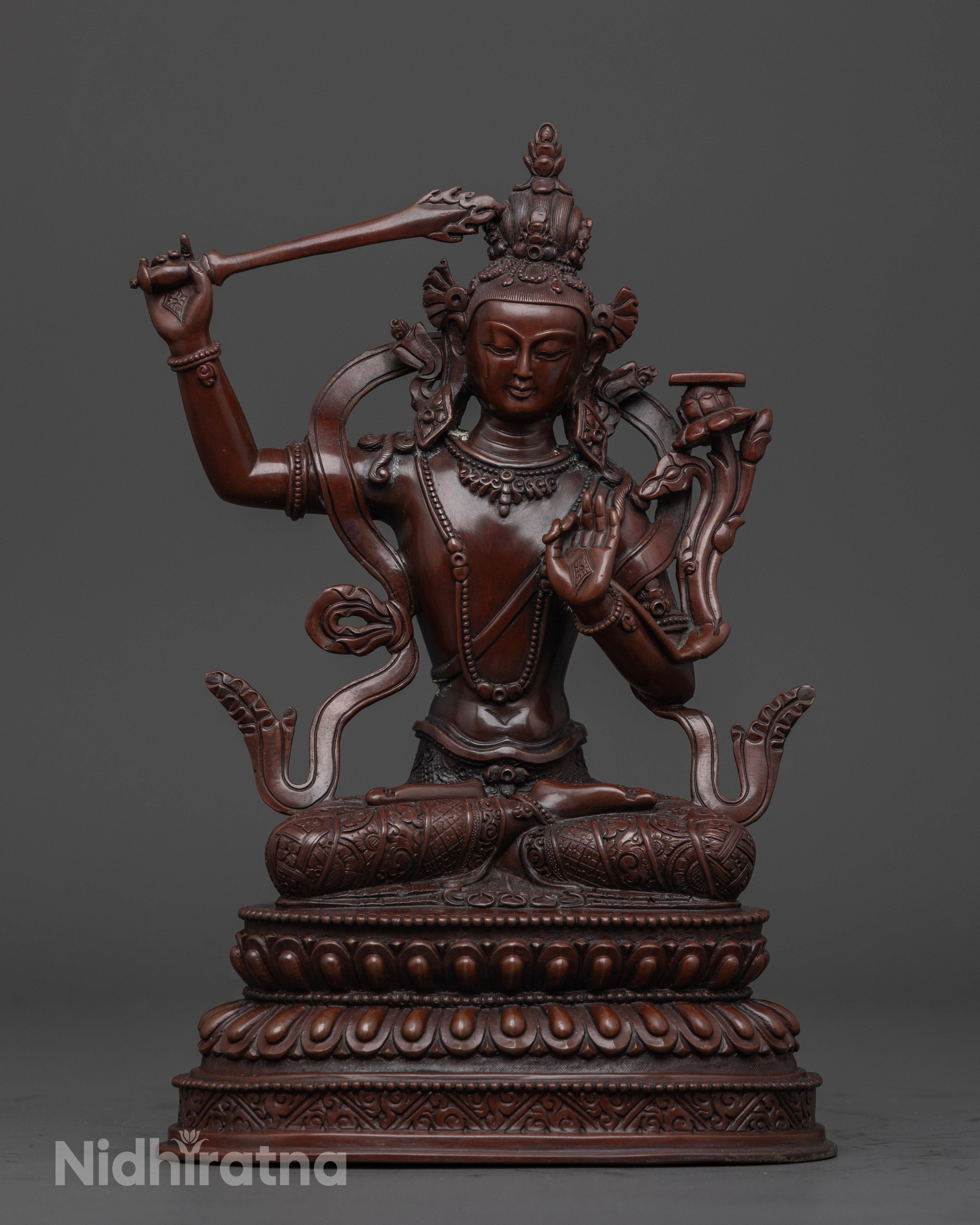 oxidized manjushri statue holding a sword with a book on a flower
