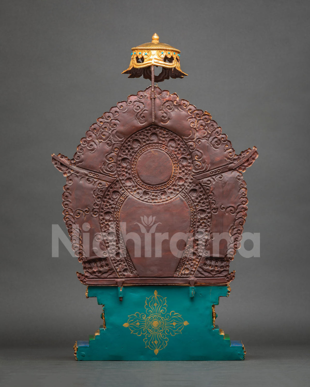 Rear view of copper halo backplate with embossed scroll motifs and parasol finial on Buddha statue