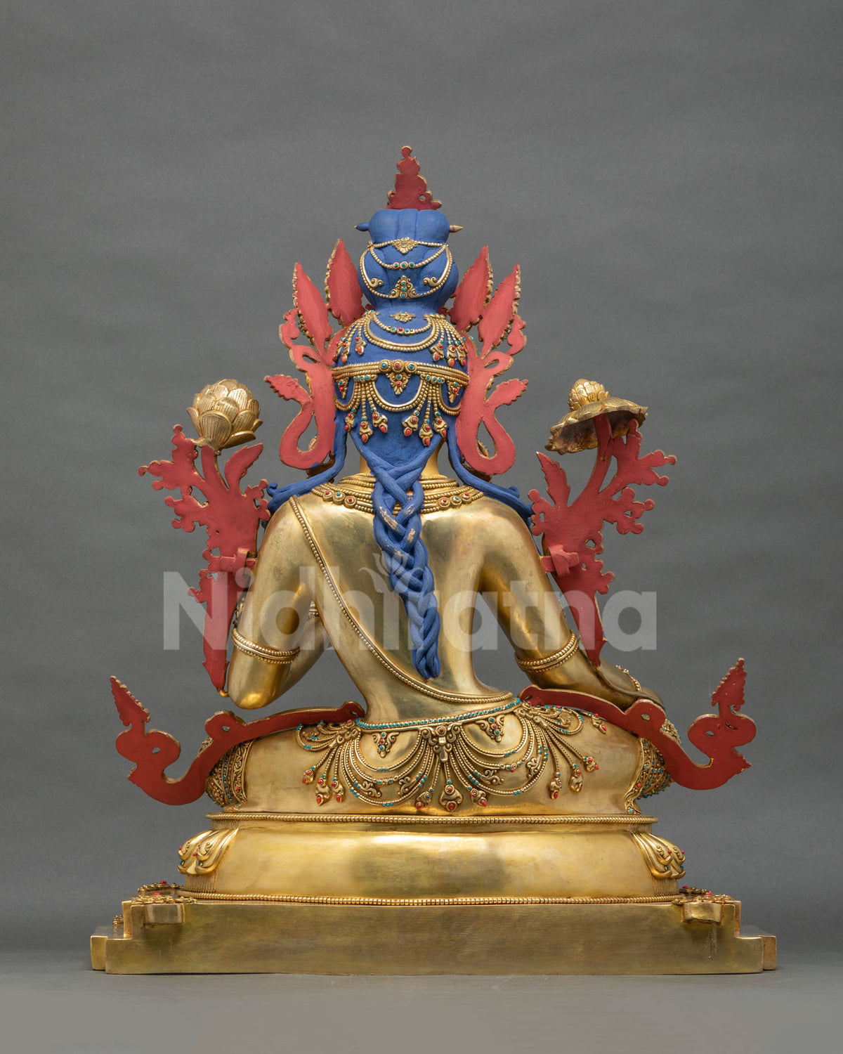 Rear view of Green Tara statue with braided hair and jeweled details, fire-gilded copper alloy