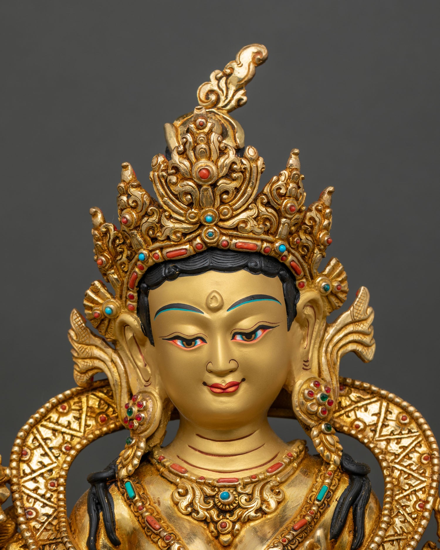 regular close-up of green tara statue showing intricate copper and gold features on altar-ready sculpture