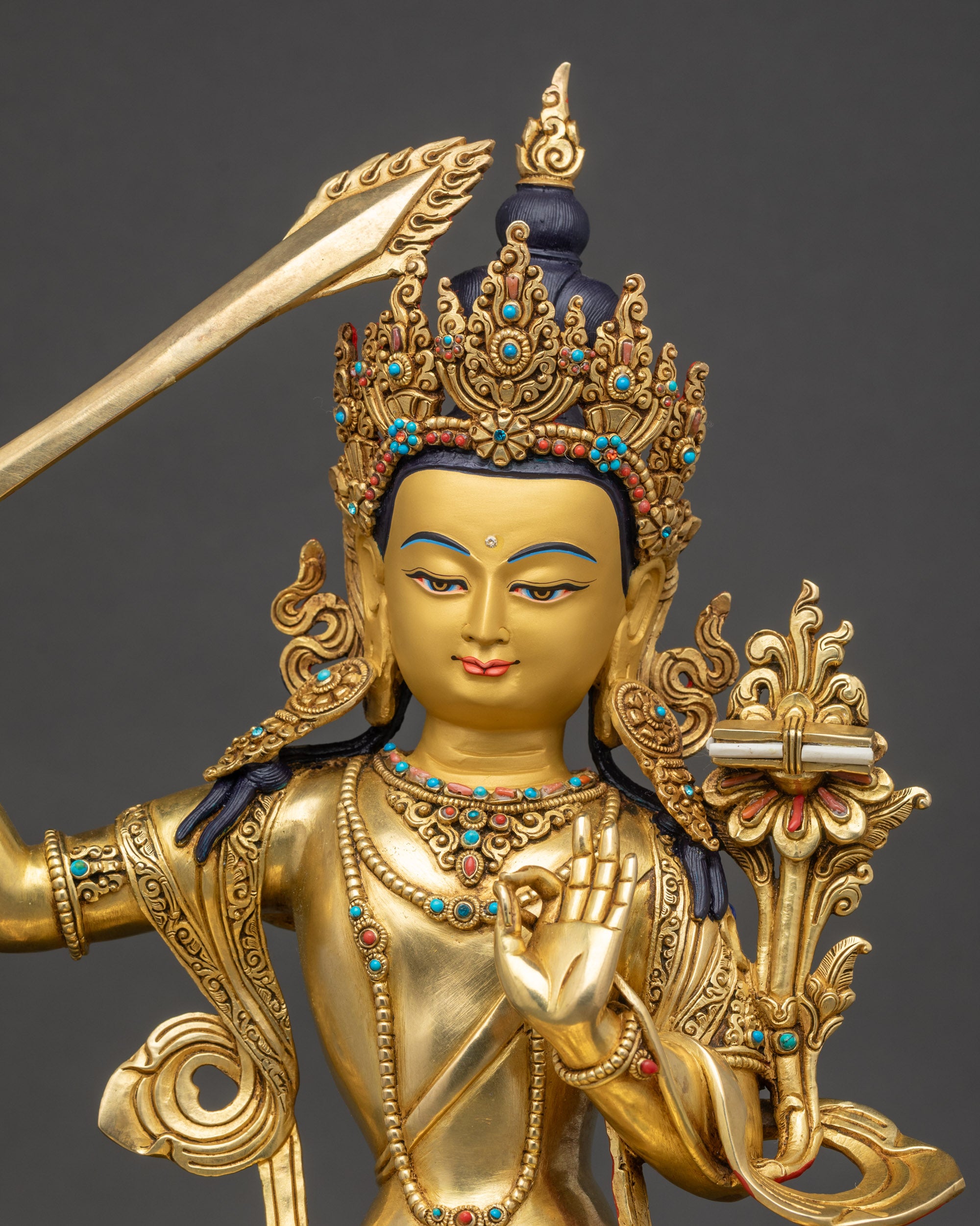regular close up Manjushri Buddha statue showing intricate lotus seat and gold gilding