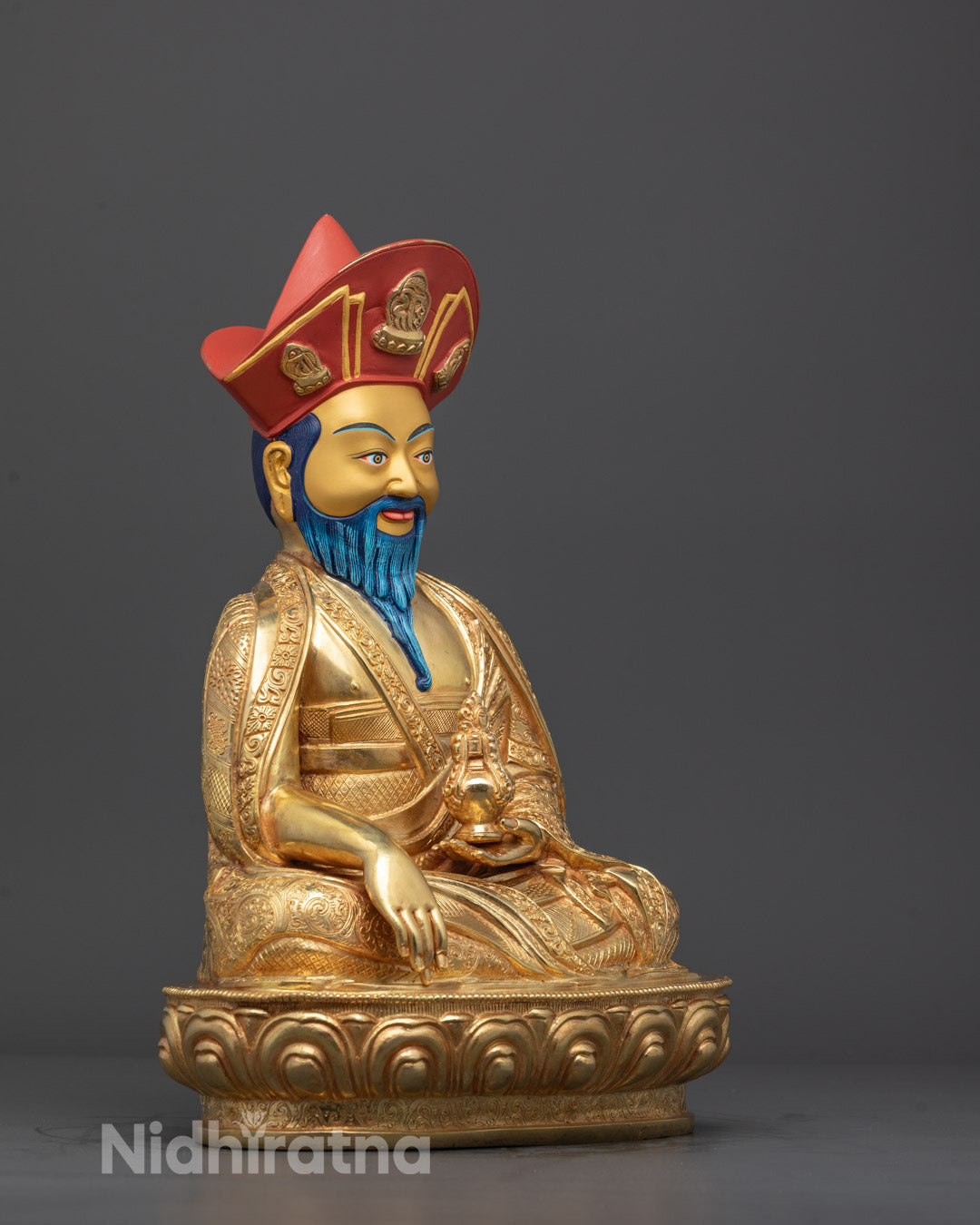 Right profile of Shabdrung Rinpoche statue with lotus base, semi-precious stone adornments, and gold finish