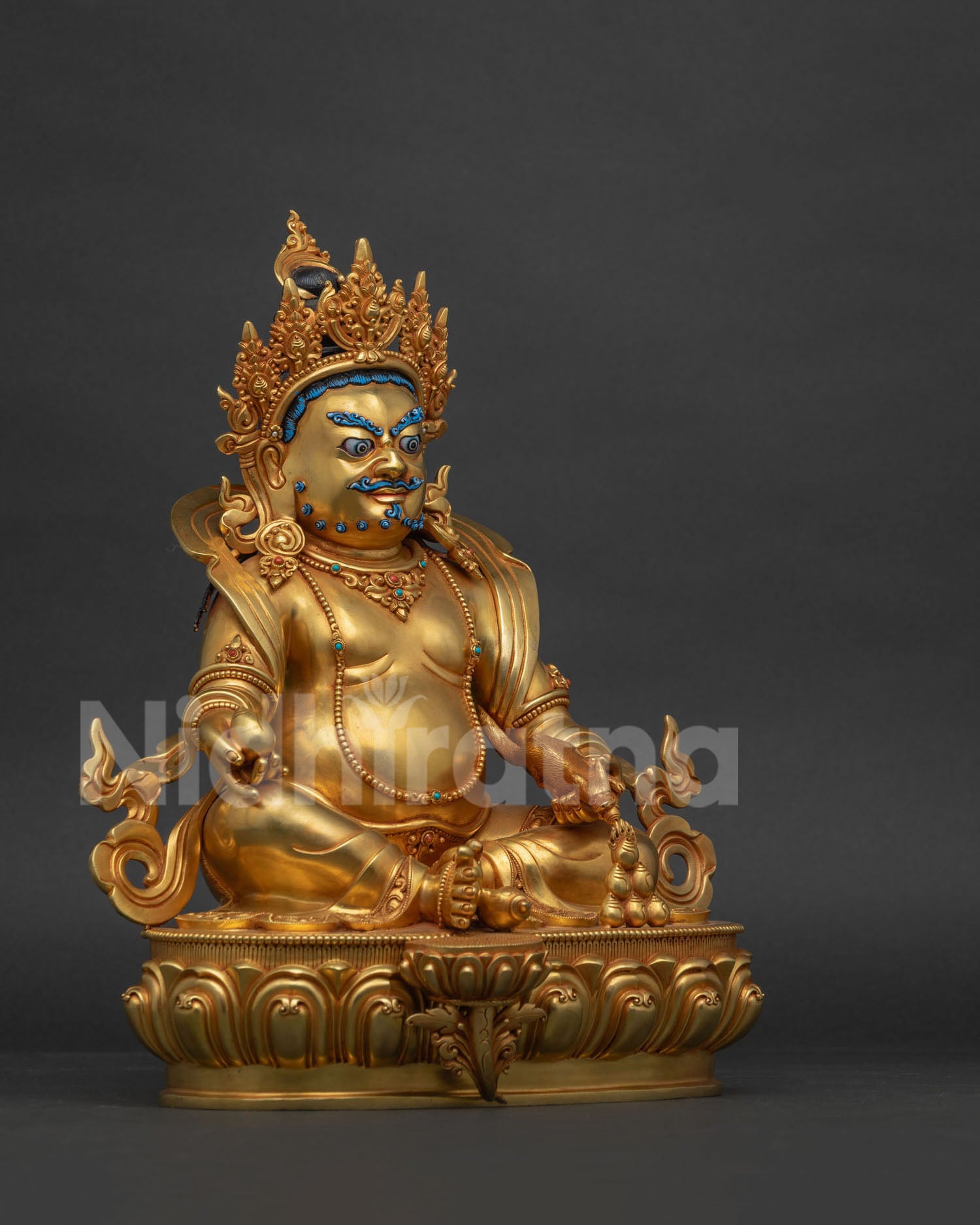 Right side view of gold fire-gilded Dzambhala statue on carved lotus base