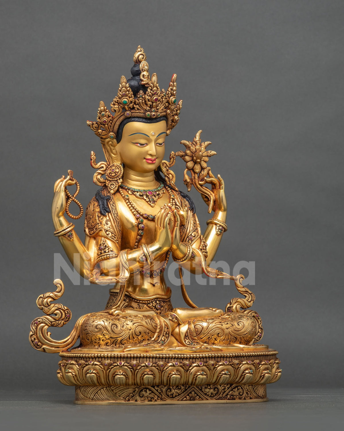 Right side view of gold-gilded four-armed Avalokiteshvara sculpture.
