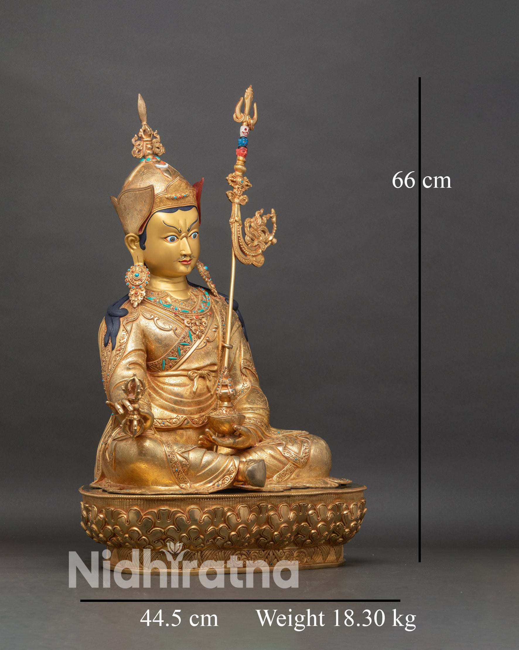 Right side view of Guru Rinpoche statue holding vajra and kapala skull cup with khatvanga staff