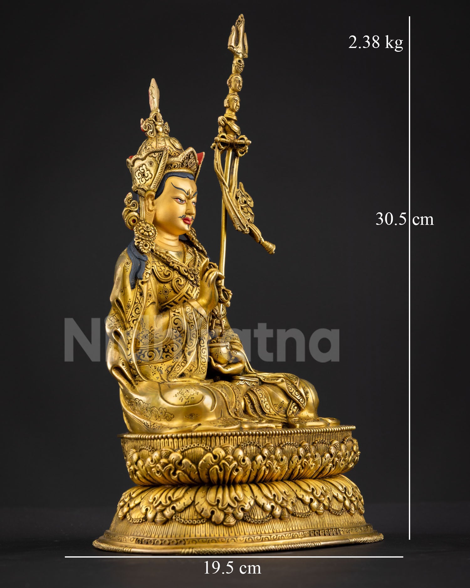 Right side view of Guru Tsokye Dorje statue holding vajra and ritual kapala