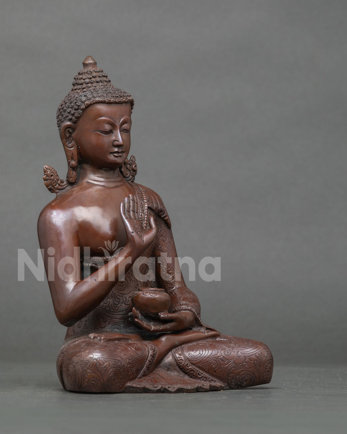 Right side view of oxidized copper Amoghasiddhi Buddha statue in seated meditation pose