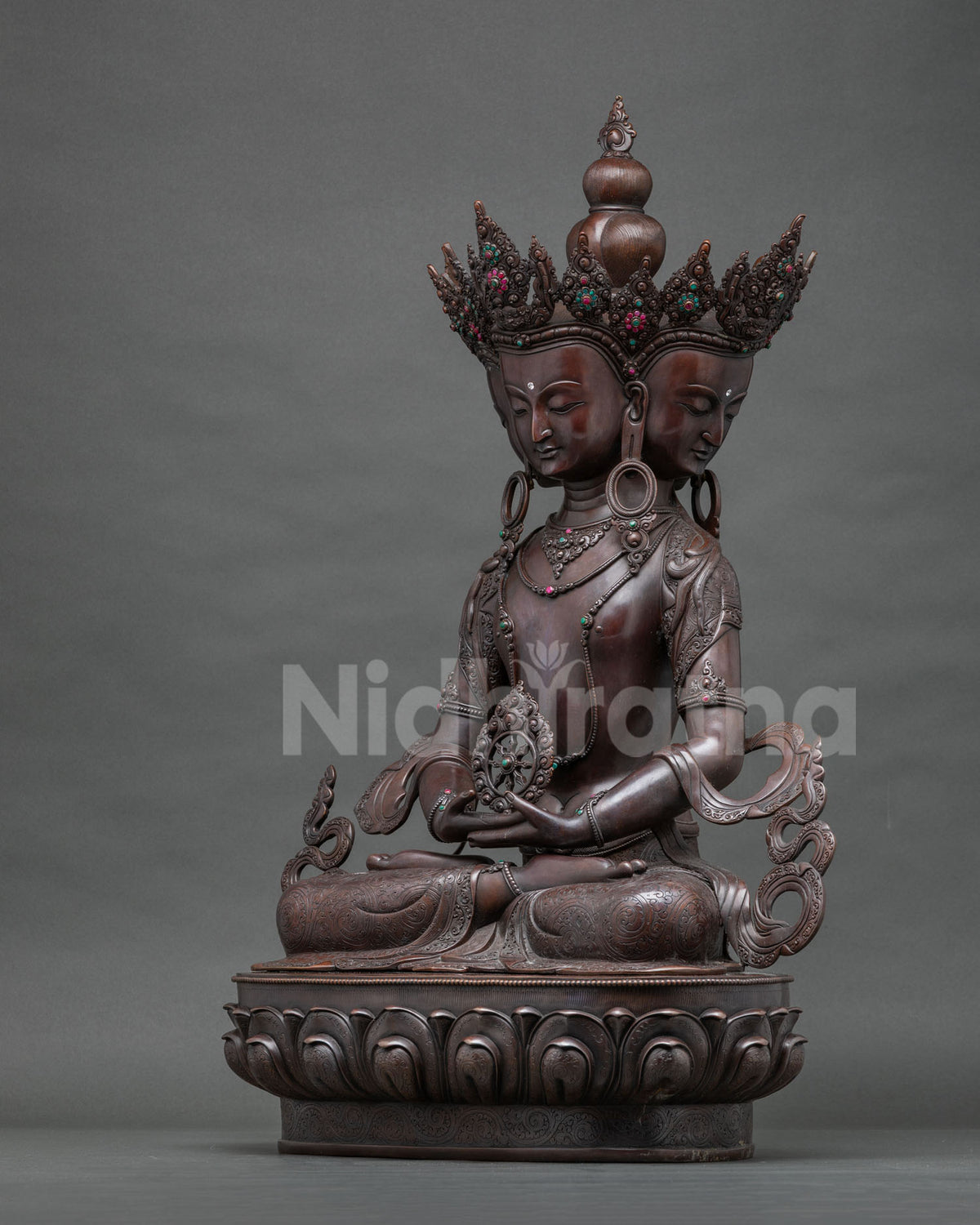 Right side view of the four-faced Vairocana Buddha statue with flowing scarves on a lotus base