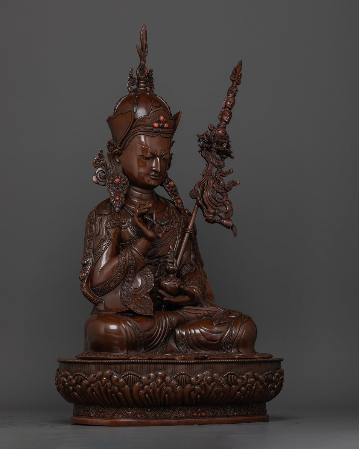 Right side view of Tsokye Dorje statue with lotus throne and oxidized copper finish