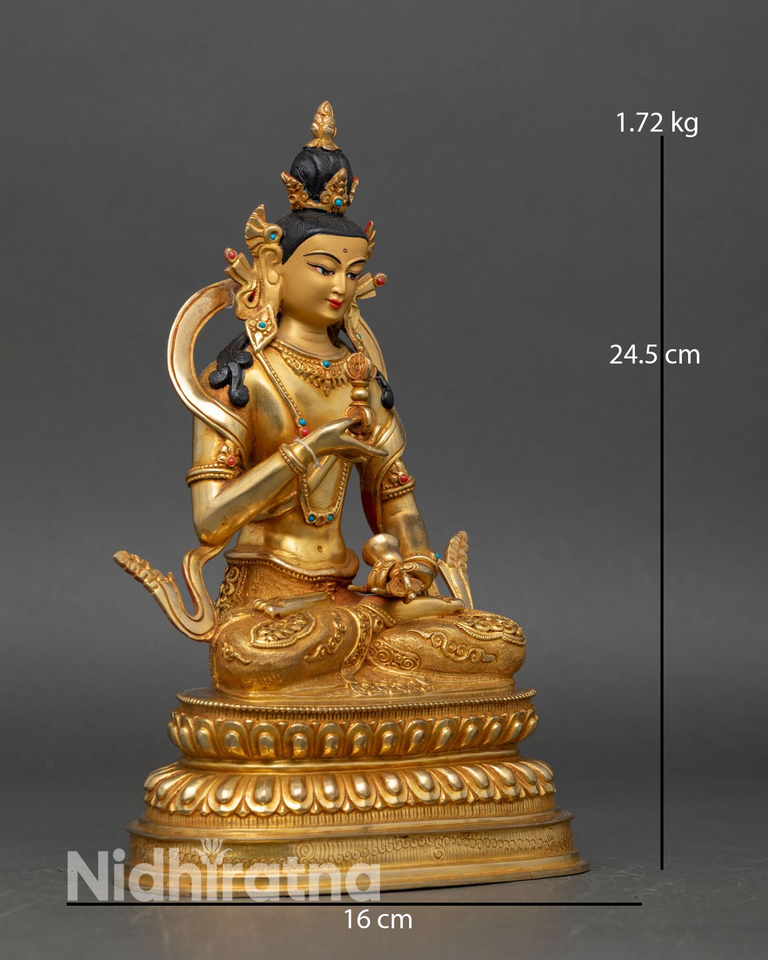 right side view of vajrasattva statue holding vajra and bell on lotus pedestal