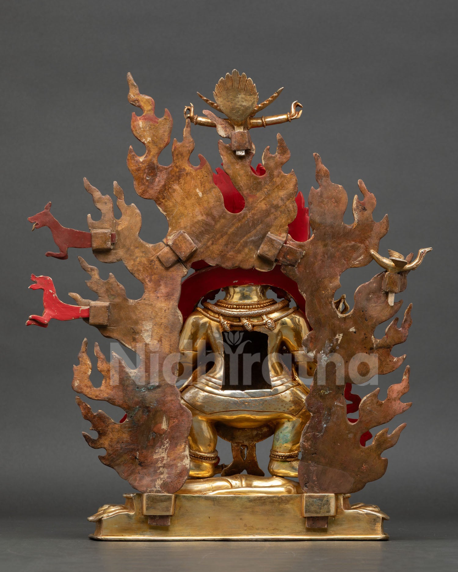 shakya mahakala statue back view, handcrafted copper sculpture with engraved details, flaming halo structure and traditional buddhist altar art