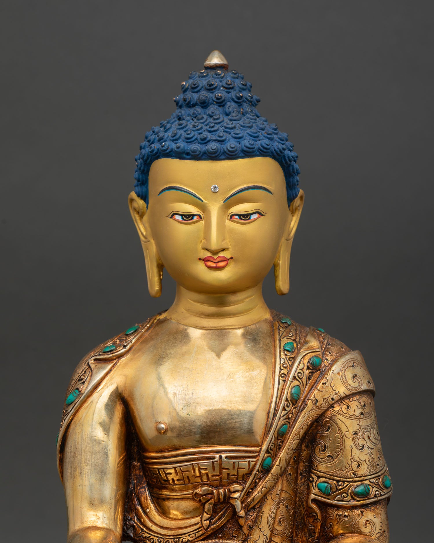 Shakyamuni Buddha face close up gold painted serene expression semi precious stone inlays