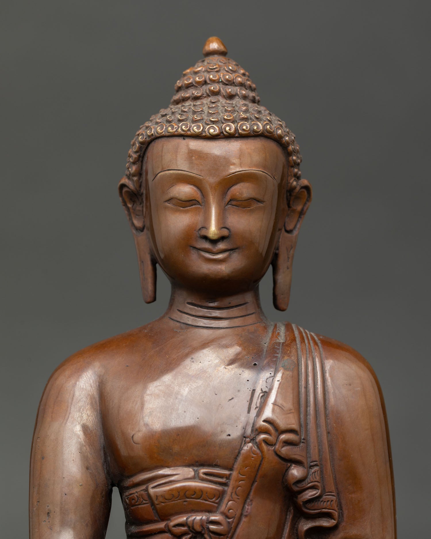 Shakyamuni Buddha face detail showing peaceful expression, traditional Nepalese craftsmanship, and spiritual serenity.