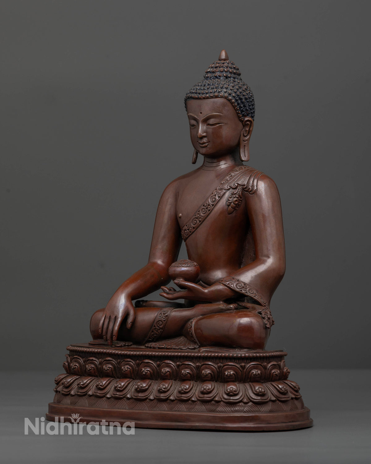Shakyamuni Buddha seated on double lotus pedestal holding a patra bowl