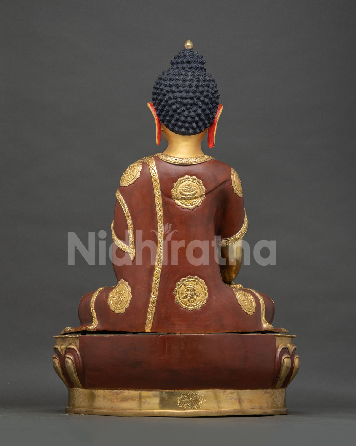 Shakyamuni Buddha statue back view, gilded robe with lotus medallion details