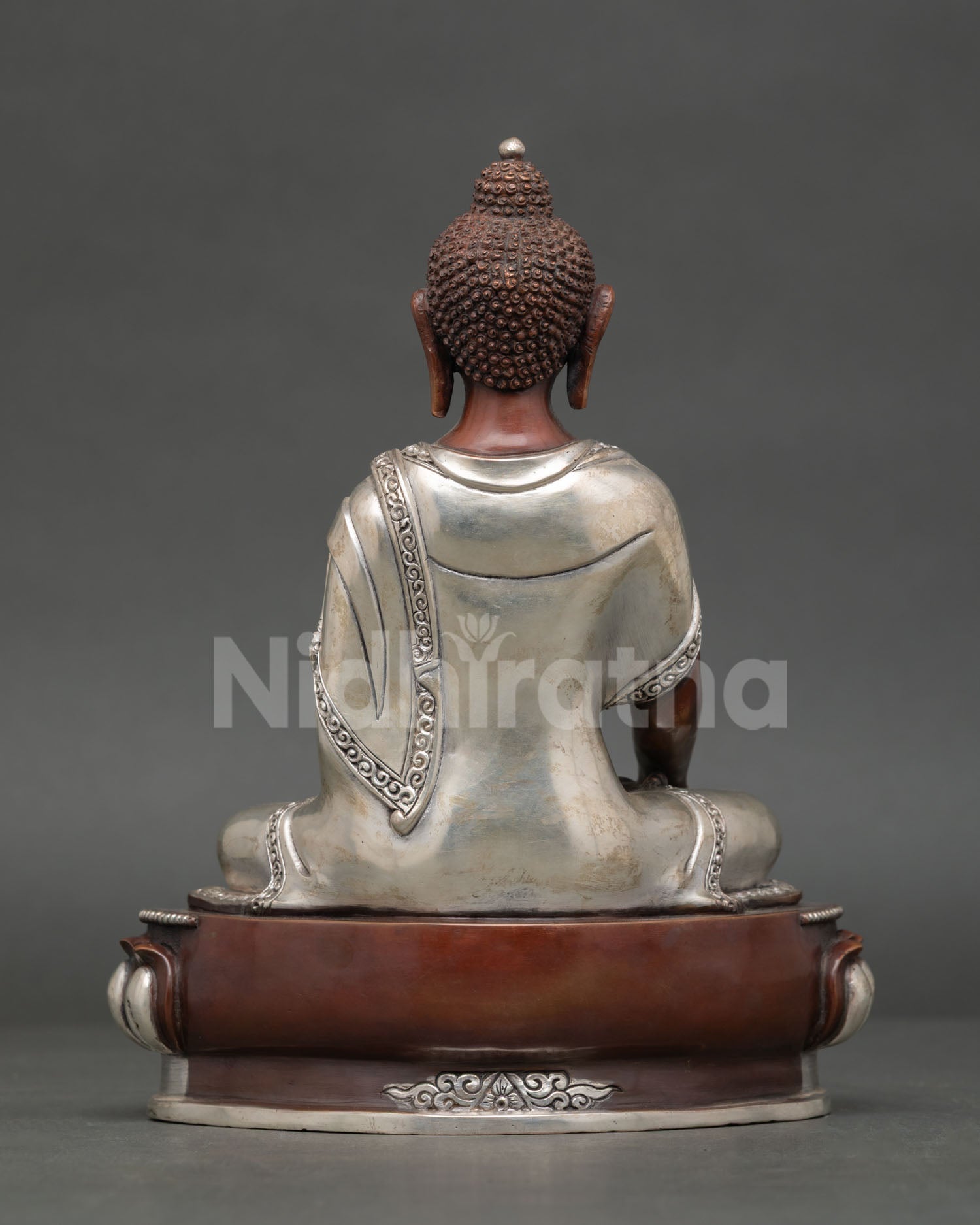 Shakyamuni buddha statue displaying intricate silver plated copper artwork and buddhist design.