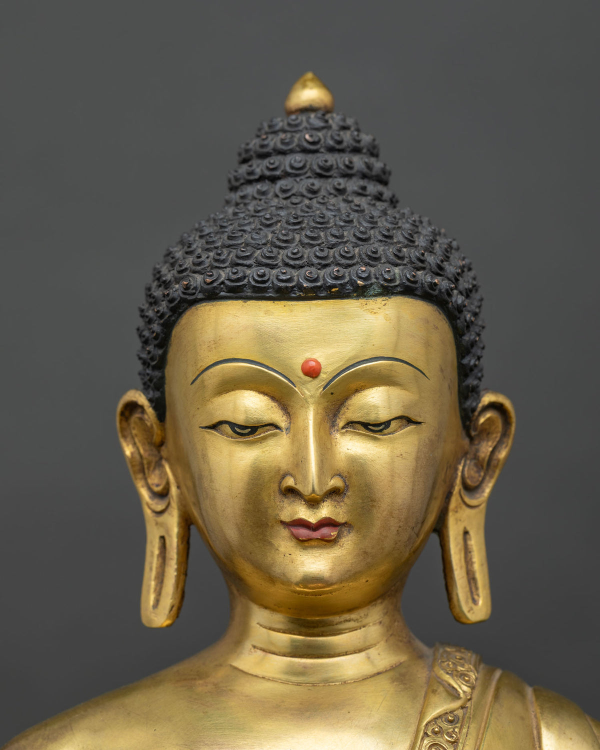 Shakyamuni Buddha Statue face detail, serene downcast eyes and ushnisha