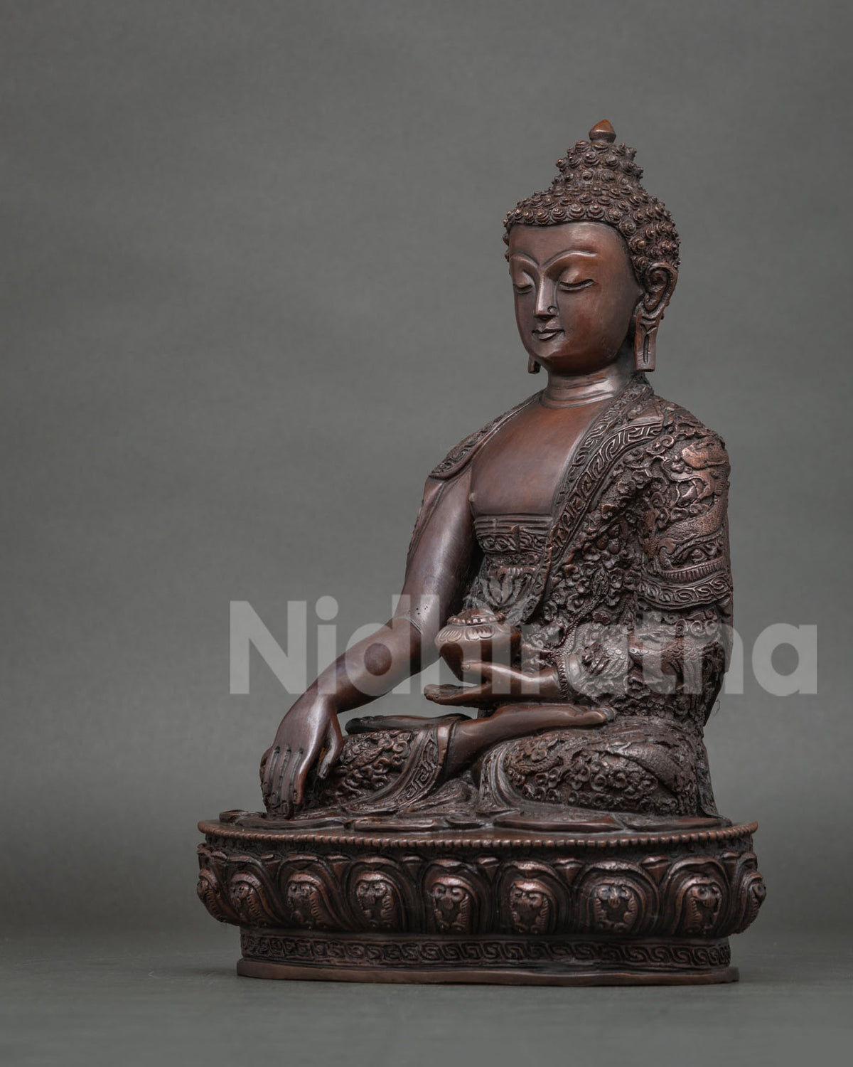 Shakyamuni Buddha statue seated on a hand carved lotus pedestal handcrafted by a skilled Newari artist from Patan Nepal.
