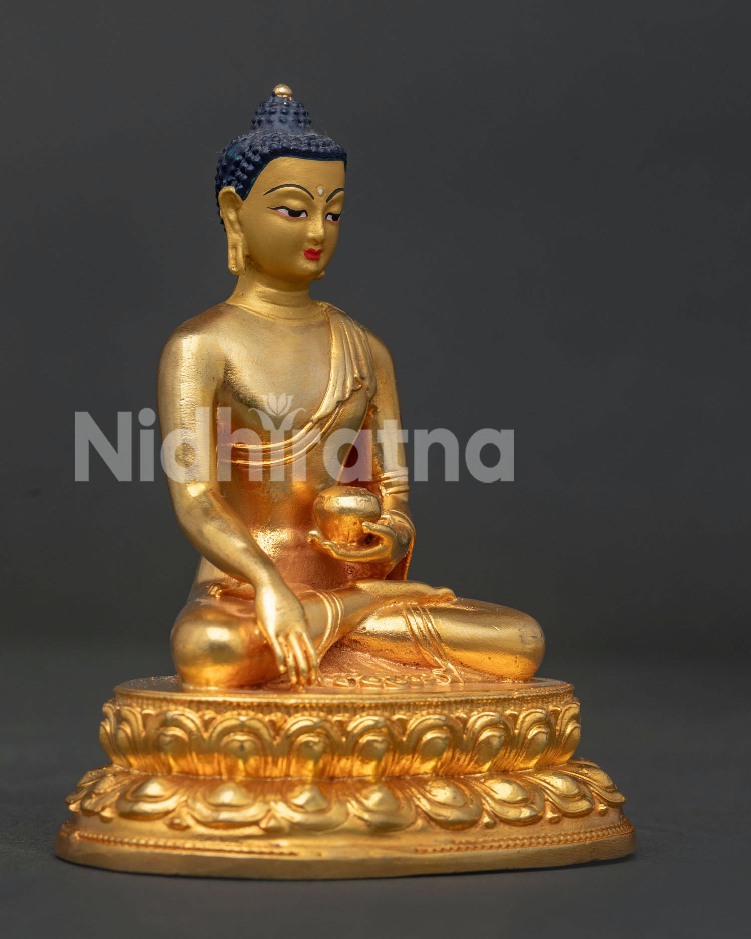 Shakyamuni Buddha statue holding begging bowl in earth touching mudra.