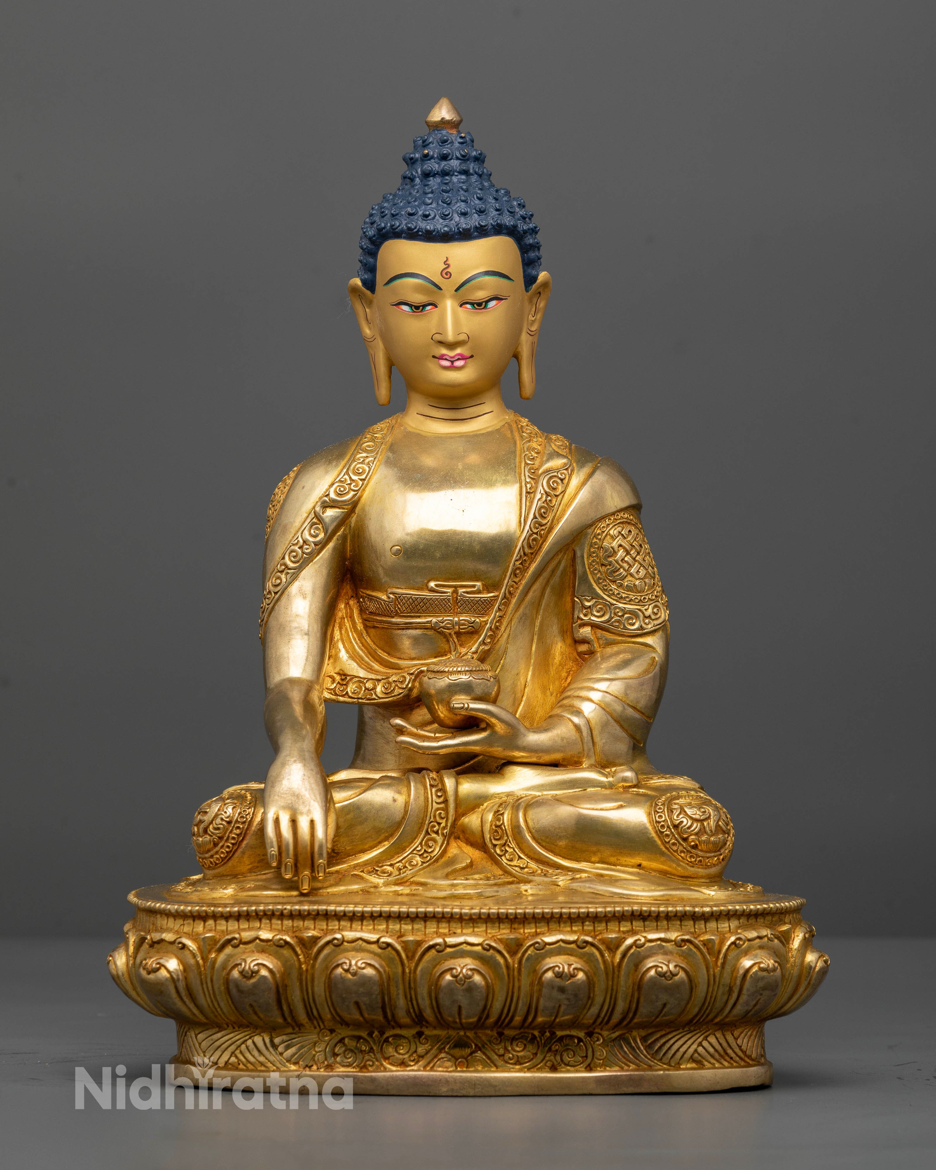 Shakyamuni Buddha statue, seated in Dhyana Mudra with a begging bowl and gold painted face