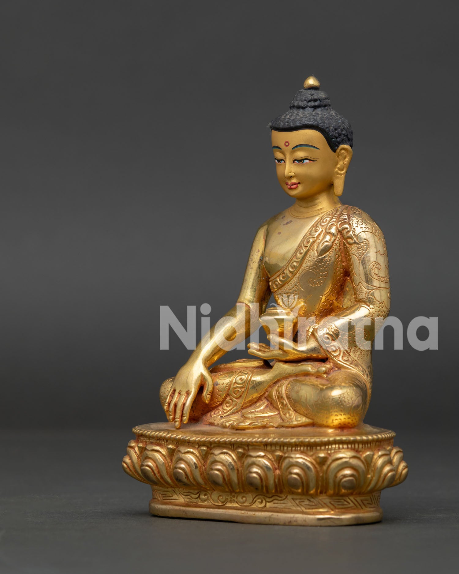 Shakyamuni Buddha statue showing earth-touching mudra and floral robe carving.