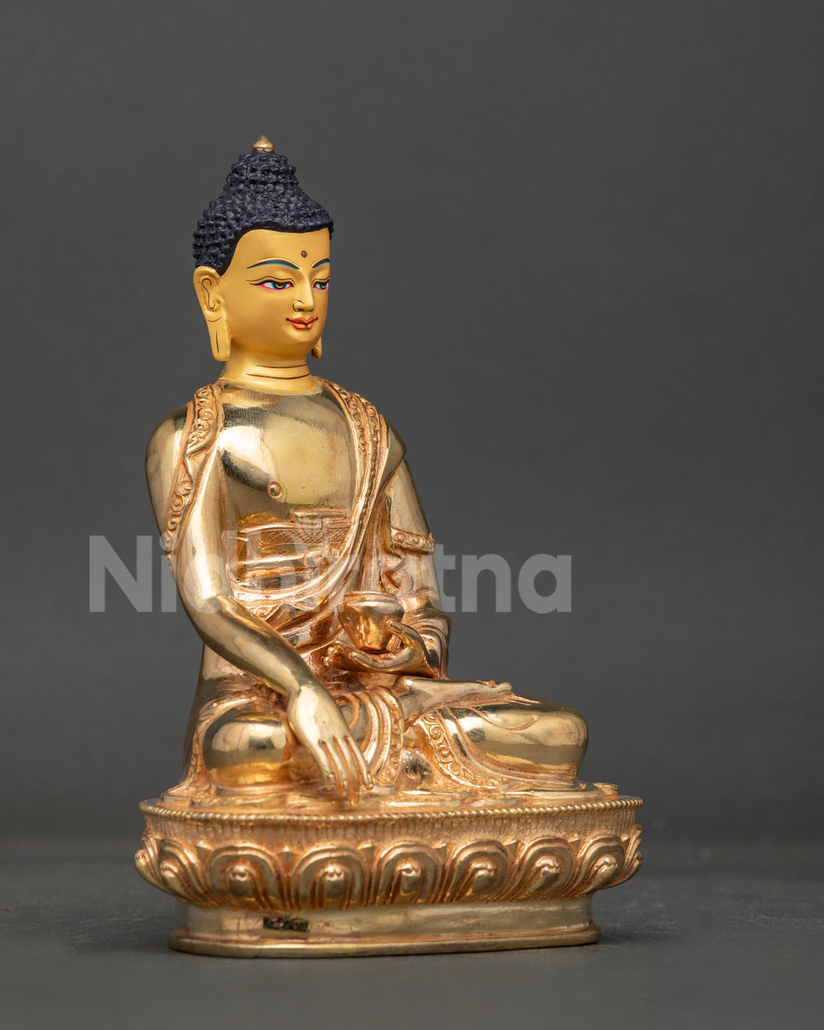 Shakyamuni buddha statue showing earth touching mudra and traditional alms bowl in meditation posture.