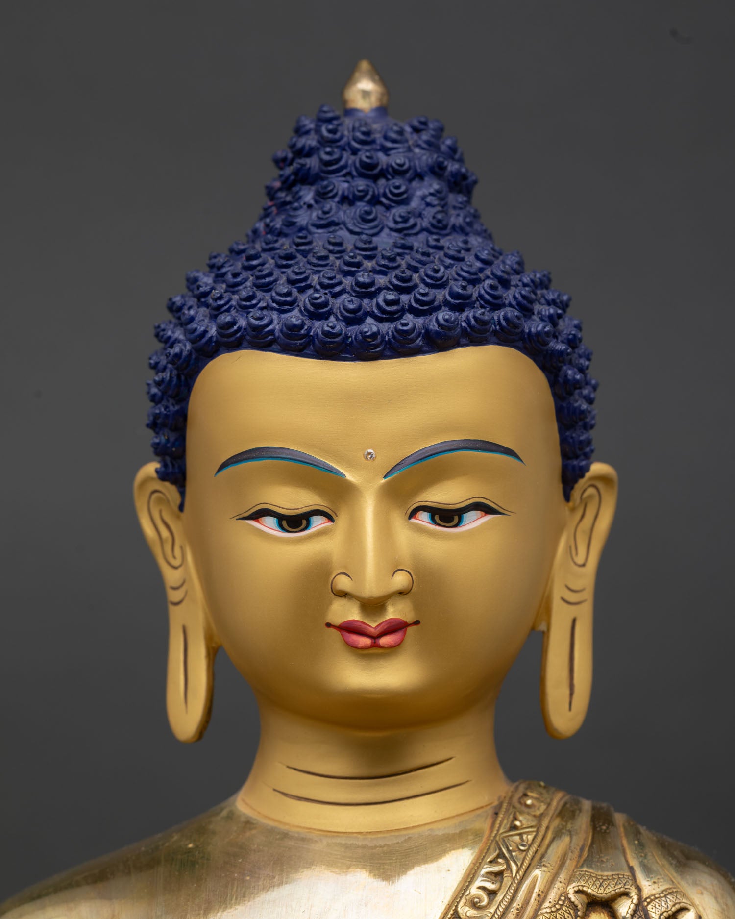 Shakyamuni Buddha face close-up gold painted serene eyes downcast meditation expression
