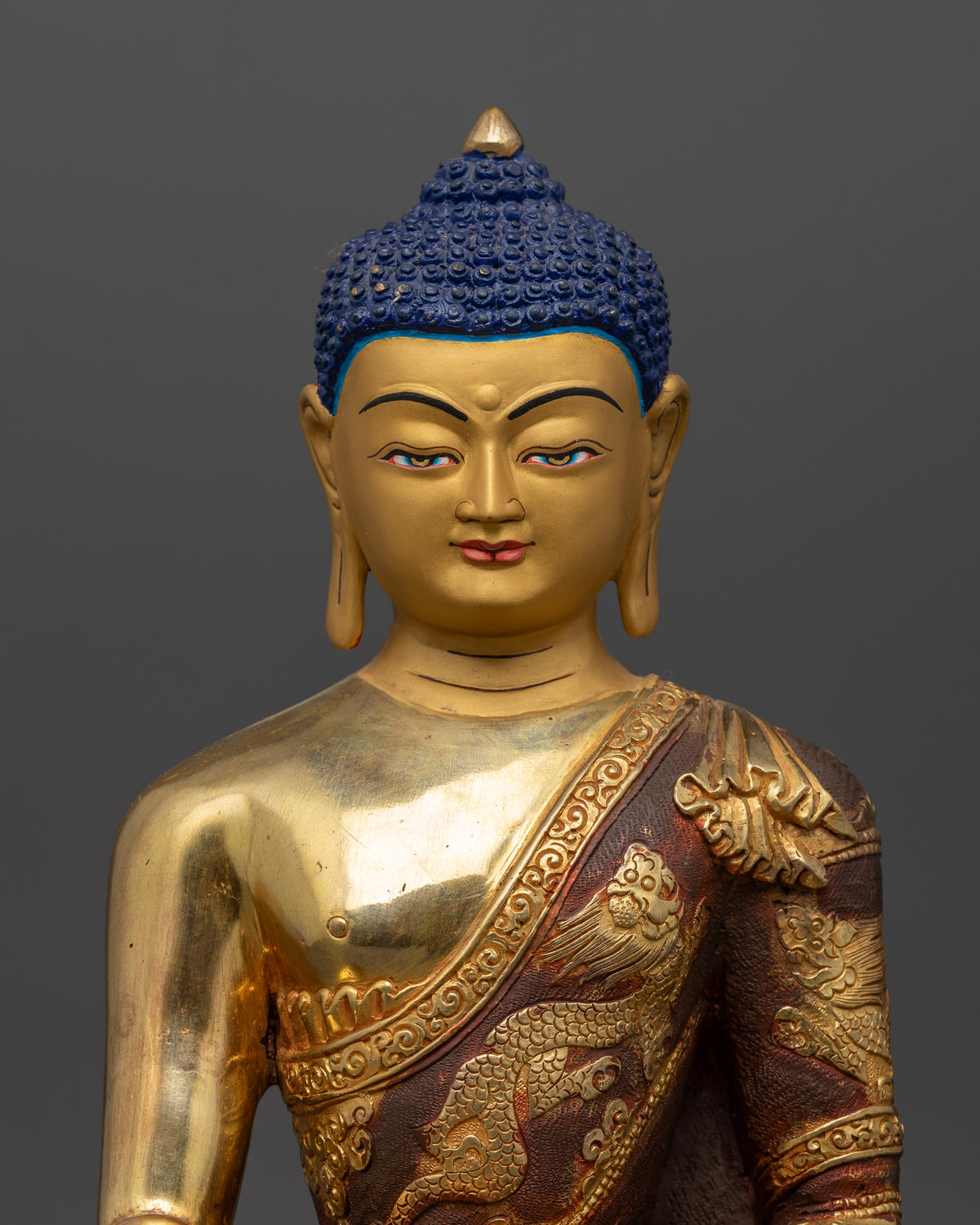 Shakyamuni Buddha statue with 24K gold painted face and dragon motif robe.