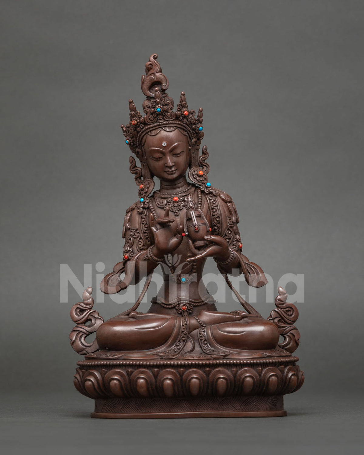 Siddhisambhava Tara statue with hands at her heart, source of attainments, oxidized copper
