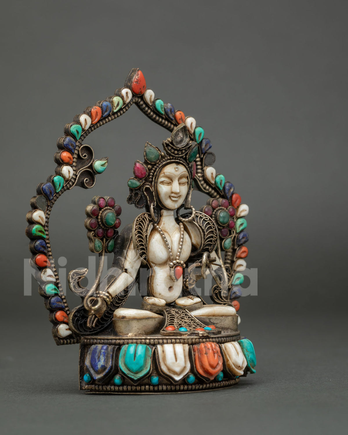 Side angle of Goddess White Tara figurine with filigree detailing and lotus pedestal