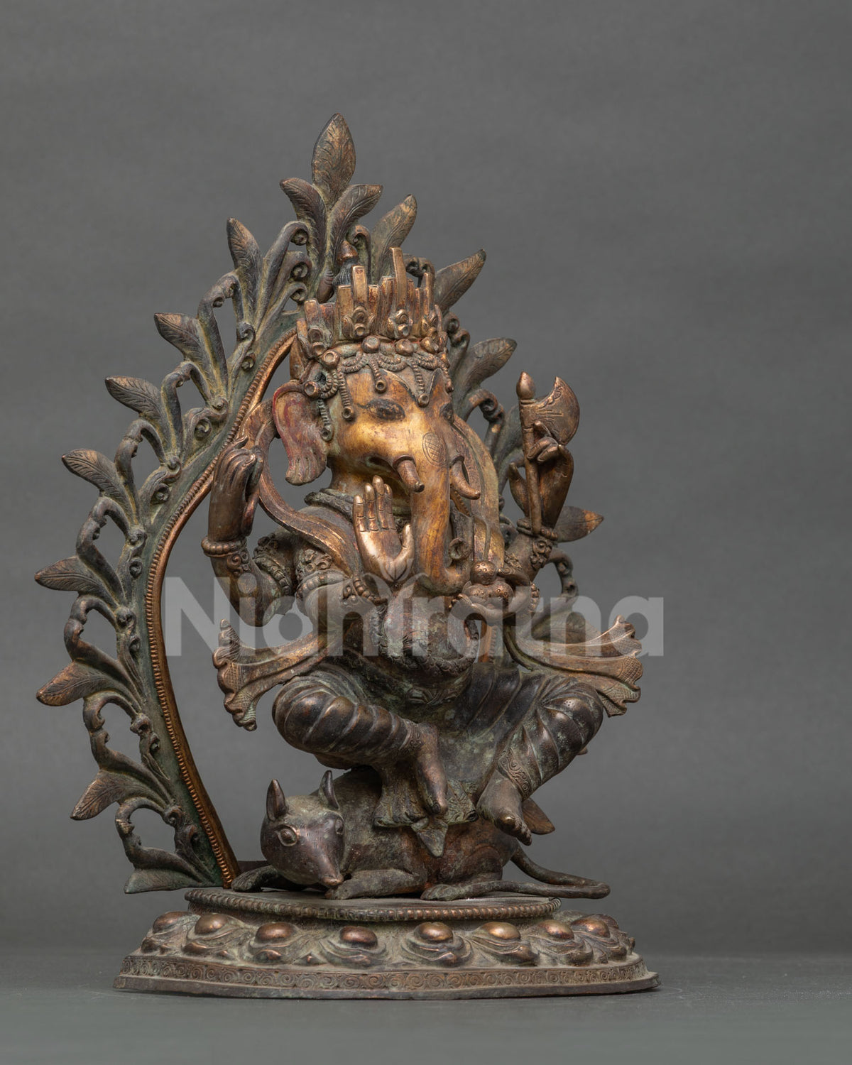Side angle of handcrafted oxidized Ganesh idol on Mushaka with ornate halo backdrop
