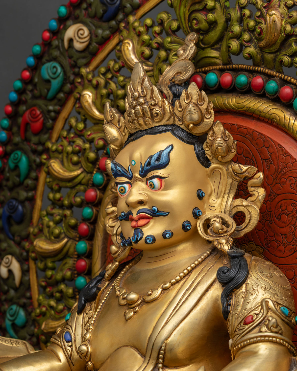 Side close-up detail of gold gilded Dzambhala throne statue, handmade in Nepal