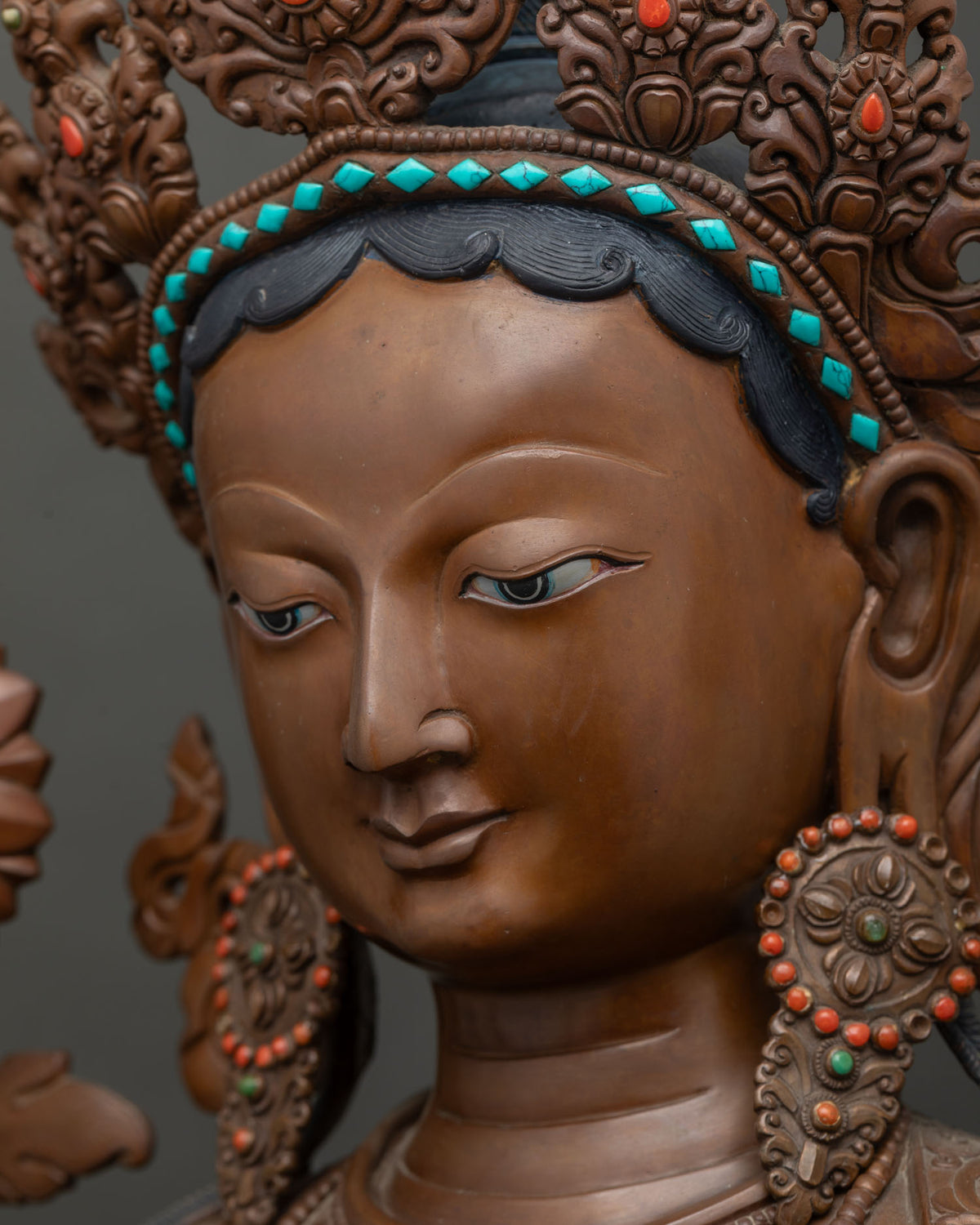 Side close-up of Green Tara statue's face with hand-painted tranquil eyes