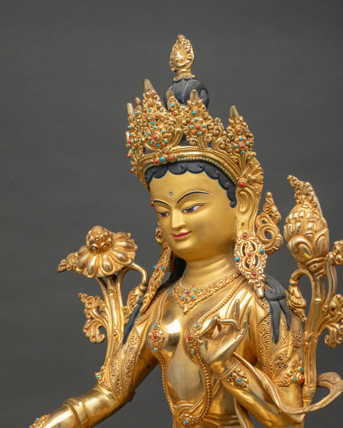 Side close up of Green Tara statue showing repoussé detailing and gemstone inlay