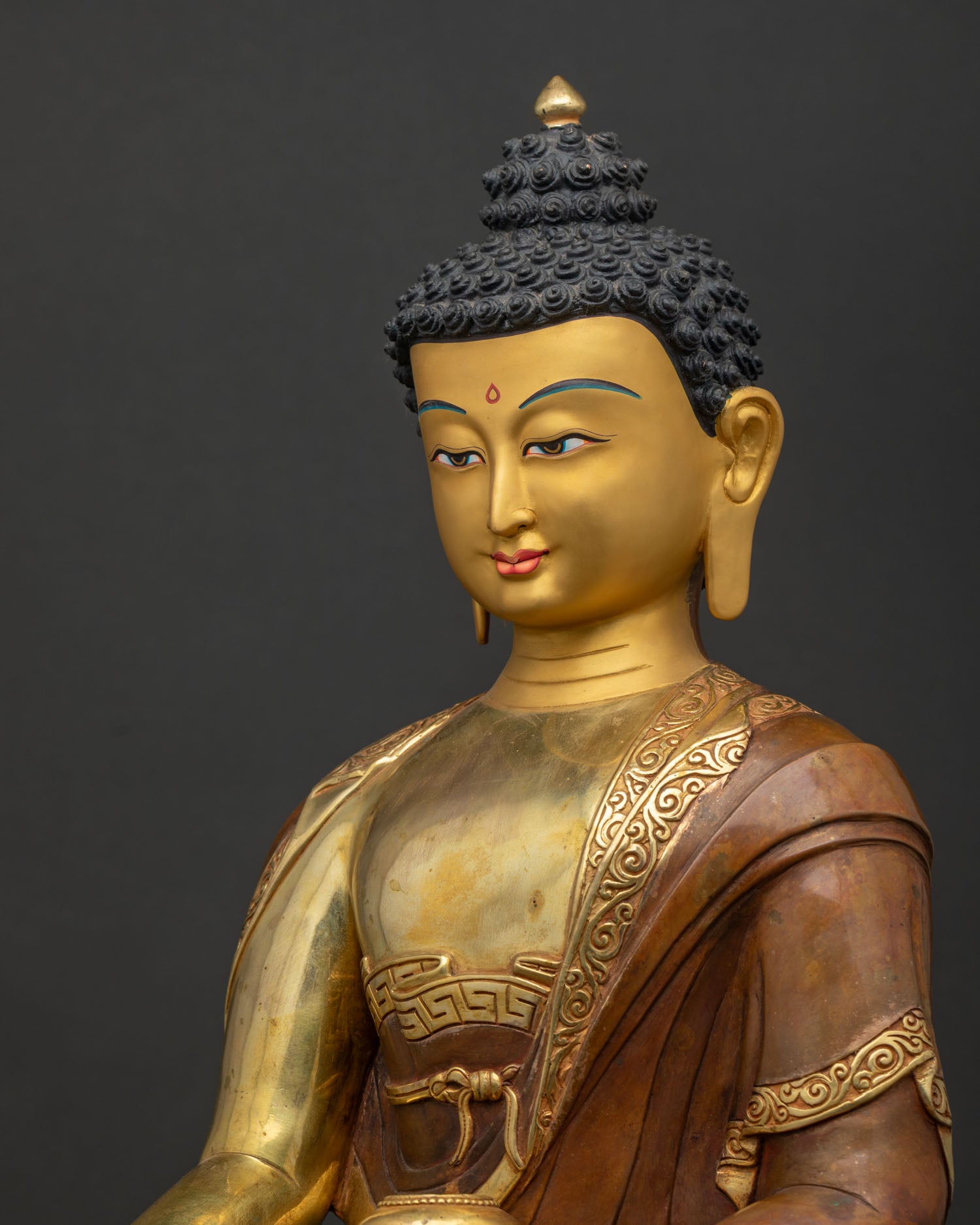 Side close-up of handcrafted copper Buddha statue with fire-gilded finish