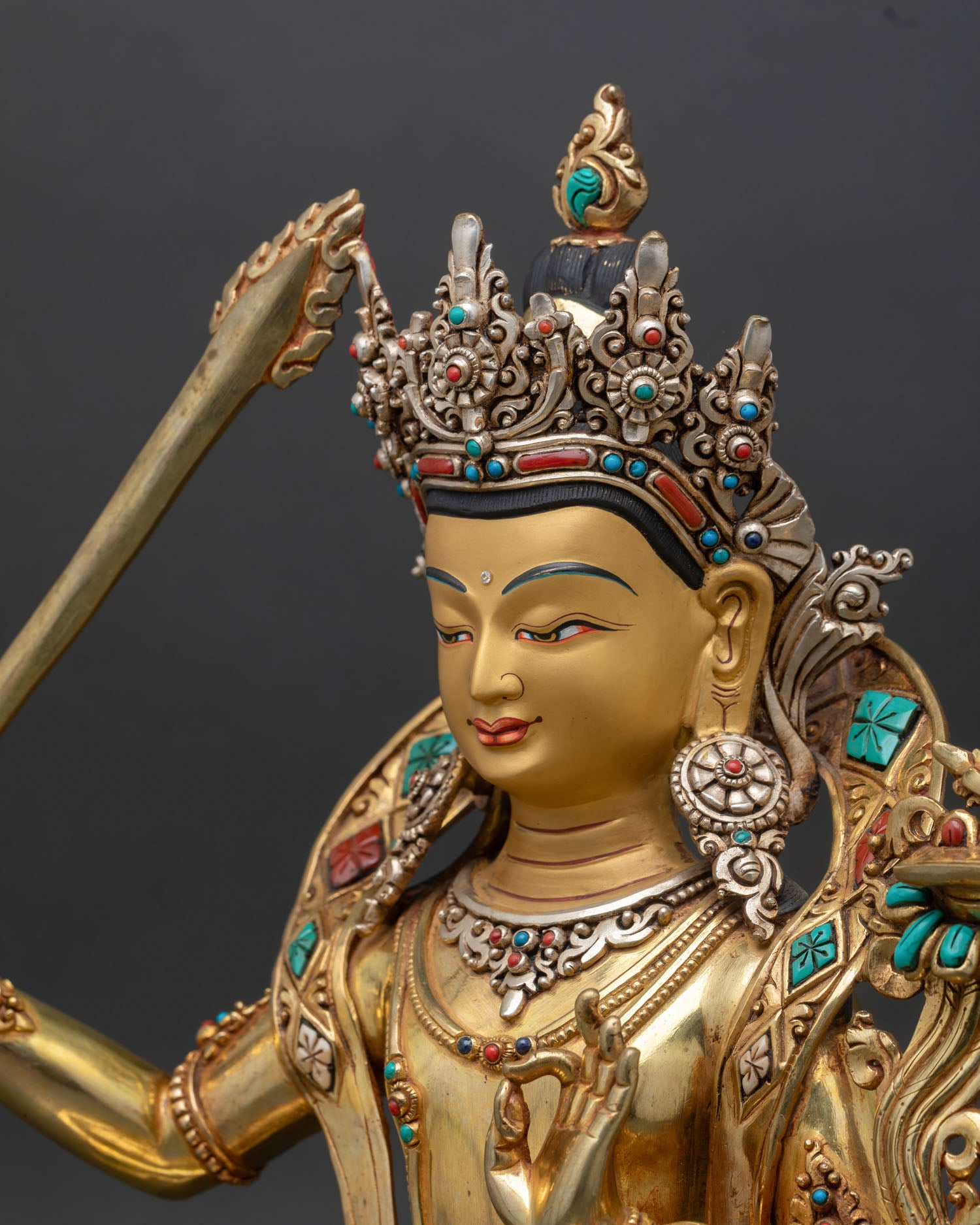 Side close-up of Manjushri statue, flowing robes, gemstone inlay details, copper and gold craftsmanship