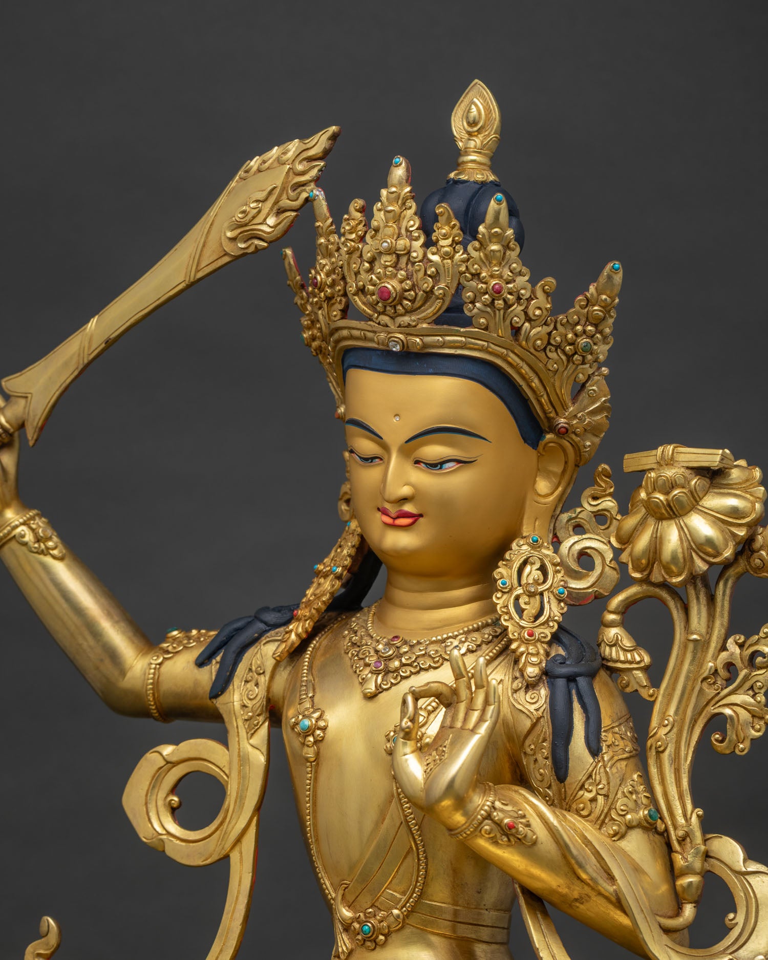 Side close up of Manjushri Statue highlighting flaming sword and hand-chased artistry