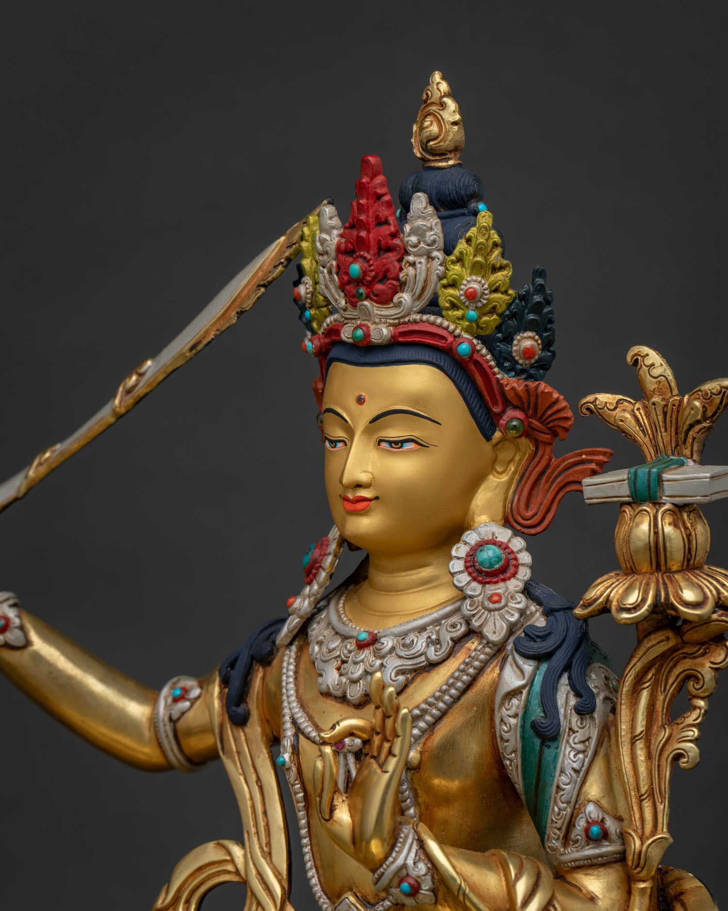Side close-up of Manjushri statue showing flaming sword of wisdom detail