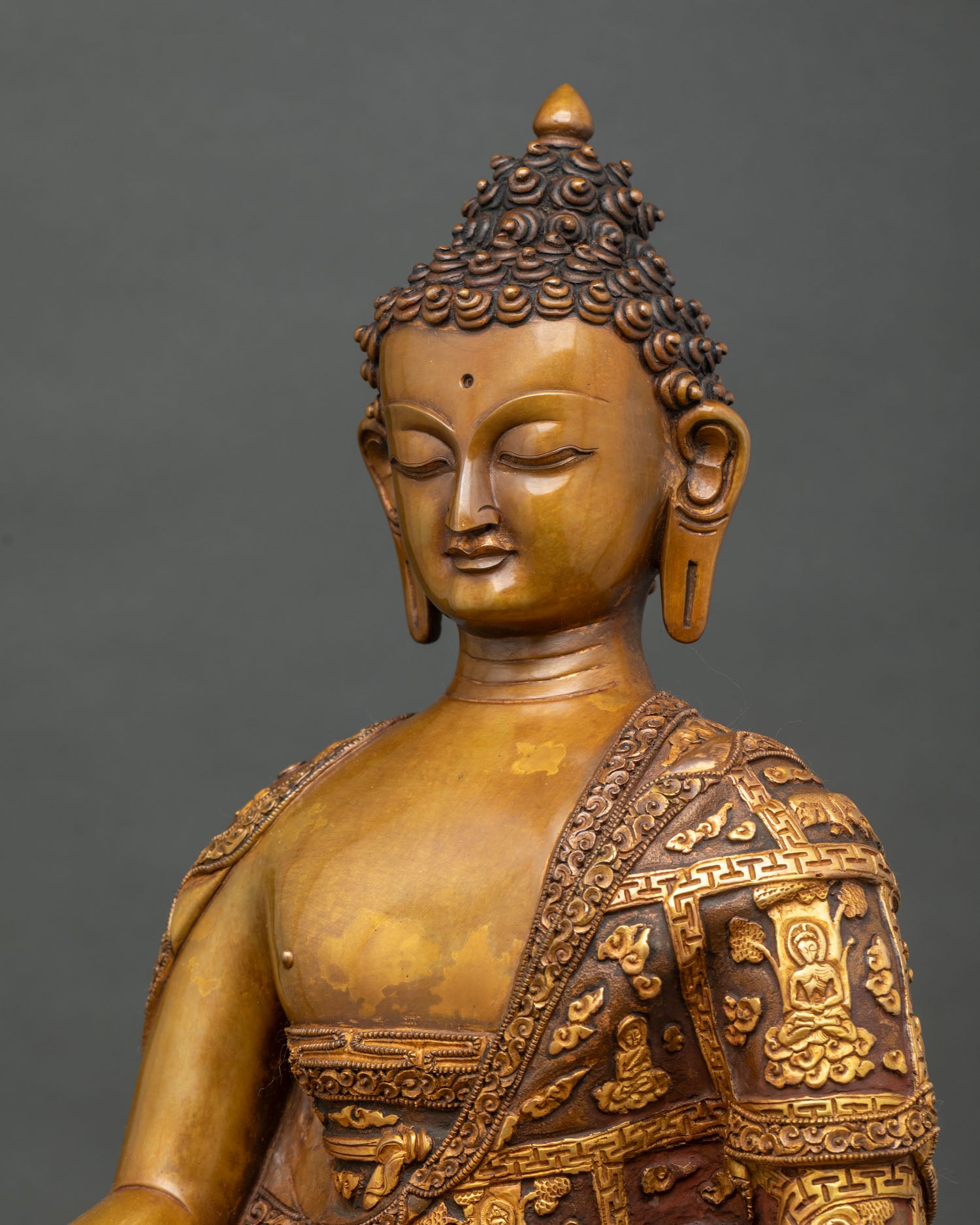 Side close up of Shakyamuni Buddha robe with gold-gilded Buddhist life scenes floral and celestial carvings